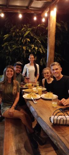 a group of people sitting around a wooden table at EYA Ecolodge in San Isidro