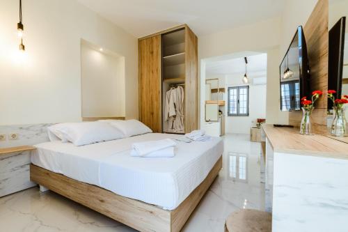 um quarto com uma grande cama branca e uma casa de banho em Emeli Suites em Chania Town