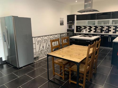 une cuisine avec une table en bois et un réfrigérateur dans l'établissement Villa Tenjin chambre 2, à Bondy