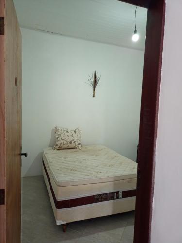 a bedroom with a bed in a white wall at Camping e Hostel Praia do Saco in Estância