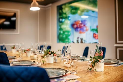 a long table with plates and glasses and flowers at Hotel Nordic Twins & Wellness in Rădăuţi