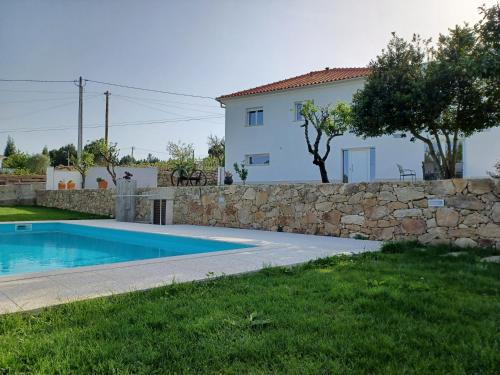 a villa with a swimming pool and a stone wall at Casa dos Picoutos AL in Monção