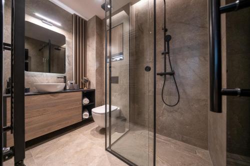 a bathroom with a shower and a toilet and a sink at VELVET rooms & more in Zadar