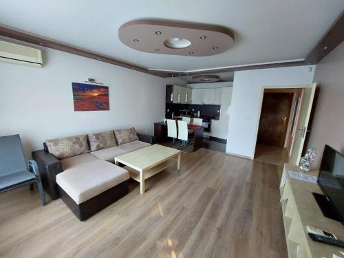 Apartment А13 in Sea Paradise Complex في كافارنا: غرفة معيشة مع أريكة وطاولة