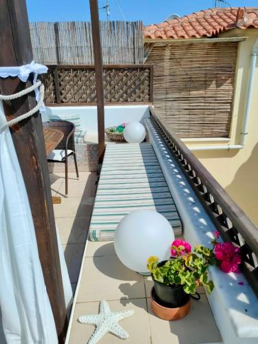 a deck with a railing and flowers on a balcony at Sea Breeze - Home with a View in Bouzéïka