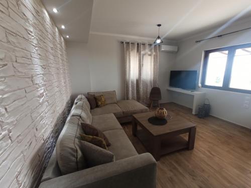 a living room with a couch and a brick wall at MELENIOS HOUSES in Samothraki