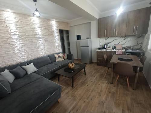 a living room with a couch and a kitchen at MELENIOS HOUSES in Samothráki