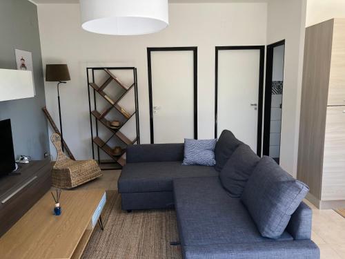 playa home في كاتانيا: غرفة معيشة مع أريكة زرقاء وتلفزيون
