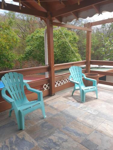 two blue chairs sitting on a porch at Seawind Cottage- Traditional St.Lucian Style in Gros Islet