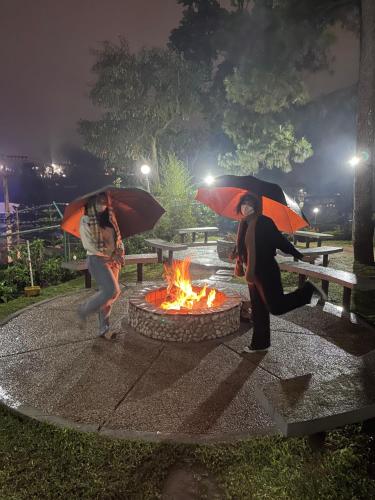 two people with umbrellas in front of a fire at M&M Residence in Baguio