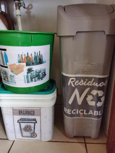 two trash cans are sitting next to a sink at Greenhouse Lofts Miravalles in Aguas Claras