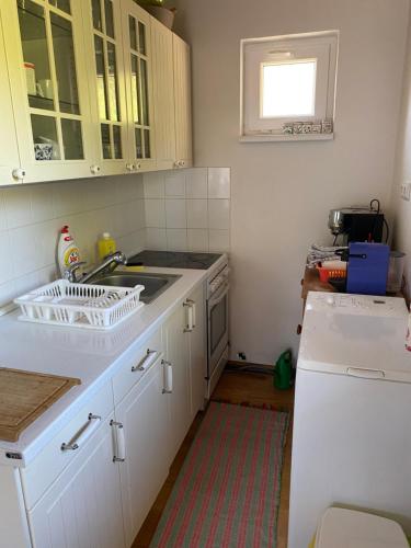 a kitchen with white cabinets and a sink at Chata U Svahu in Němčičky