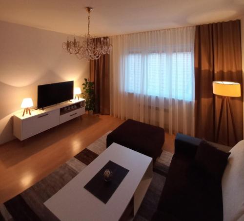 een woonkamer met een bank en een tv bij Apartment Emmi in Sarajevo