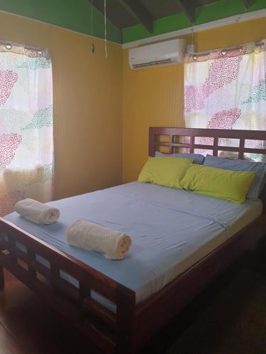 łóżko w pokoju z dwoma ręcznikami w obiekcie Seawind Cottage- Traditional St.Lucian Style w mieście Gros Islet
