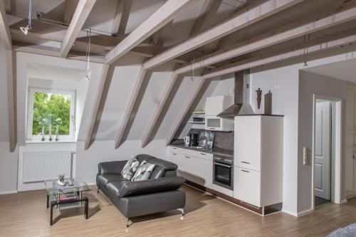 uma sala de estar com um sofá de couro e uma cozinha em Ferienwohnung TonArt em Sommerach