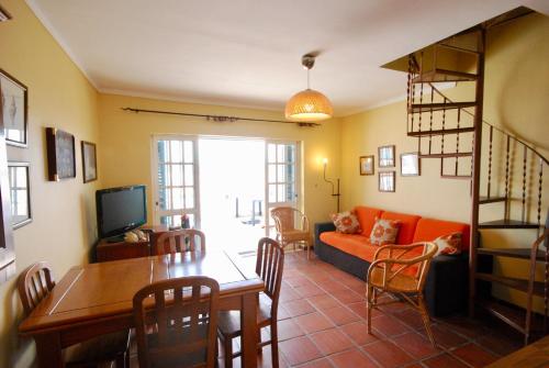 a living room with a couch and a dining room table at Sofia House - Baleal Island, Ocean view patio and bedroom in Ferrel