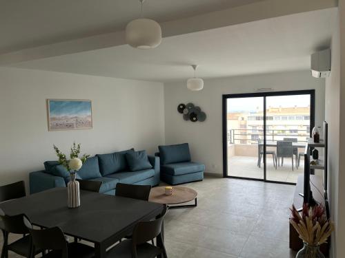 a living room with a blue couch and a table at Casa Olmia Résidence in Calvi