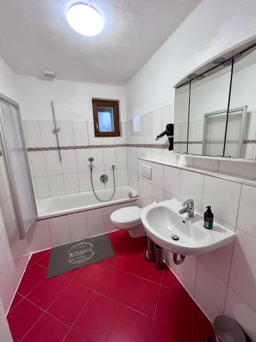 een badkamer met een wastafel, een toilet en een bad bij Ferienwohnung am Staffelsberg in Bad Kissingen