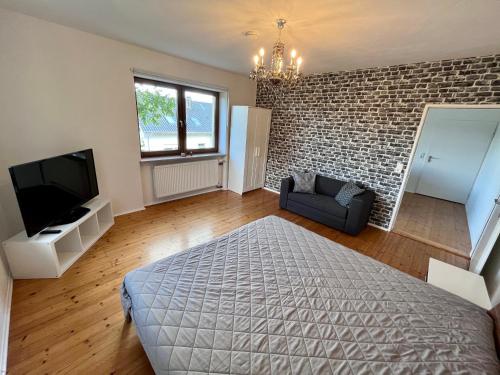 een slaapkamer met een bed en een bakstenen muur bij Ferienwohnung am Staffelsberg in Bad Kissingen