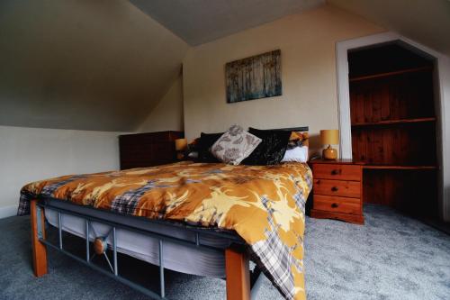 a bedroom with a bed and a wooden dresser at Jovie Apartment in Stornoway