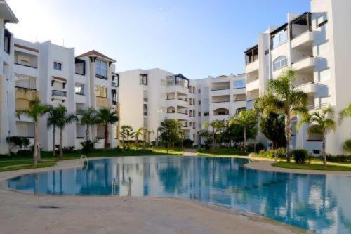 a large swimming pool in front of some buildings at Marina Golf Appart Chez Hicham in Asilah