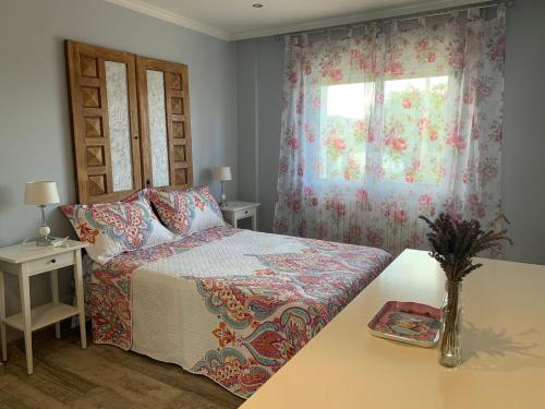 a bedroom with a bed with a table and a window at Apartamento en sanxenxo Aldodi in Sanxenxo
