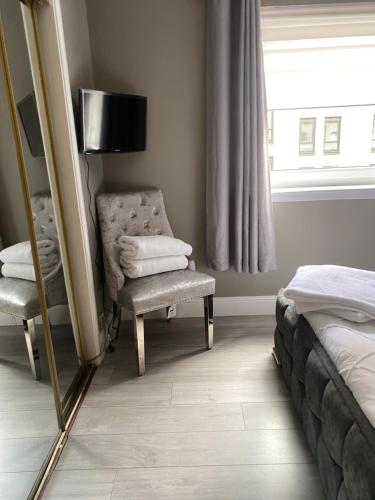 a bedroom with a mirror and a chair and a bed at 2 Bedroom Apartment at SECC Hydro FREE PARKING in Glasgow