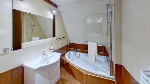 a bathroom with a tub and a sink and a shower at Chalupa Ždiar in Ždiar