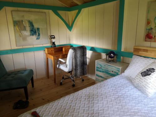 a bedroom with a bed and a desk and a chair at Dreamers Writing Farm, 3 Wooded Acres, Hepworth in Sauble Beach