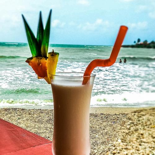 a drink in a glass on the beach at Hotel Agroturistico Palma Vino in Arboletes
