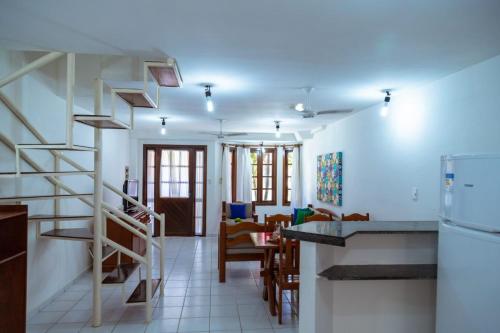 a kitchen and living room with a staircase in a room at Condominio com piscina e ótima localização. in Porto Seguro