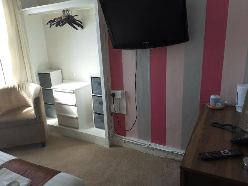 a bedroom with a room with a bed and a tv at The Coastal Bay Hotel in Blackpool
