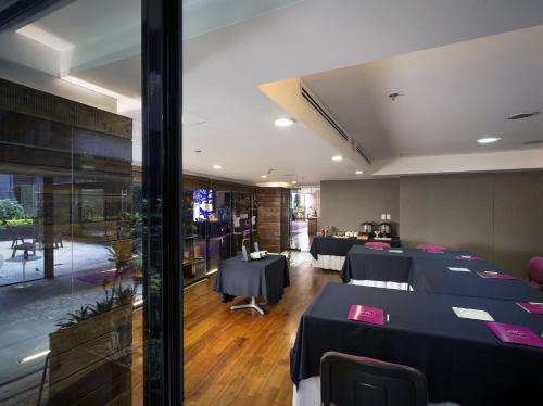 a restaurant with black tables and pink napkins at Las Suites Campos Eliseos in Mexico City