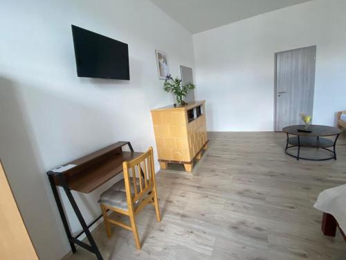 a room with a piano and a chair and a television at Pension Eberhart in Treuen