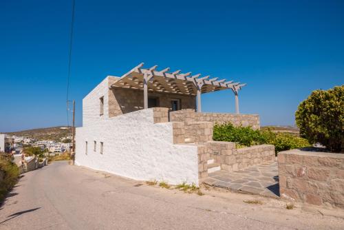 a white building with a roof on a street at Stone house Tripiti in Tripití