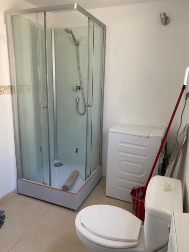 een badkamer met een glazen douche en een toilet bij Location de vacances in Alénya