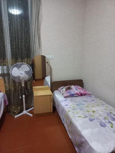 a small bedroom with a bed and a window at Guest house na Myasnikova Diamond in Novy Afon