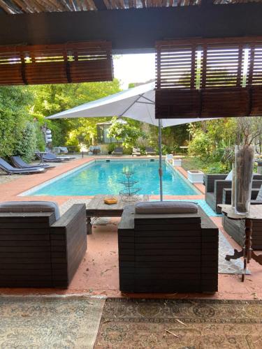 a pool with a table and an umbrella and chairs at LE 17 in Courthézon