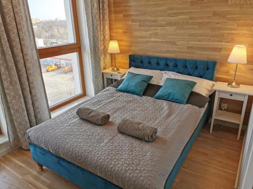 a bedroom with a blue bed with two pillows on it at Zajezdnia Wrzeszcz Apartamenty Jou in Gdańsk