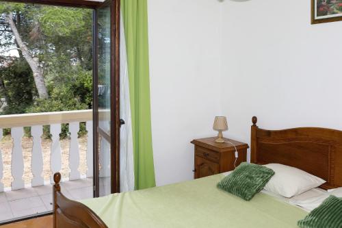 a bedroom with a bed and a balcony at Apartmani Bruno in Bibinje