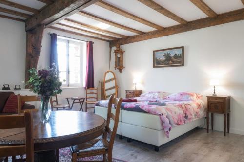 a bedroom with a bed and a table and chairs at Le Pont du Roy in Besse-en-Chandesse