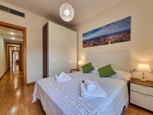 Un dormitorio con una cama blanca con toallas. en Apartment PICNIC SANTS, en Barcelona