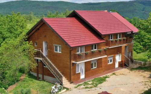 a house with a red roof on a hill at Apartments Laura in Rakovica