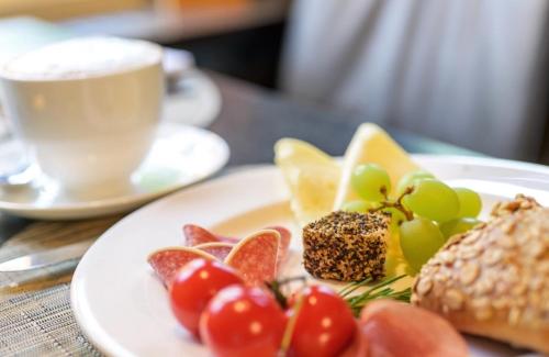 a plate of food on a table with a cup of coffee at Hotel du Nord, Hamburg-Volksdorf in Hamburg