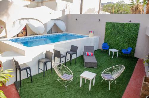 eine Terrasse mit Stühlen und einem Pool in der Unterkunft Donjuan By Melida Hotel in Cabo San Lucas