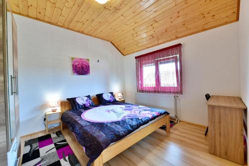 een slaapkamer met een bed en een houten plafond bij Apartments Laura in Rakovica