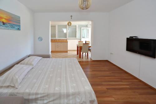 a bedroom with a bed and a dining room at Apartmani Bruno in Bibinje