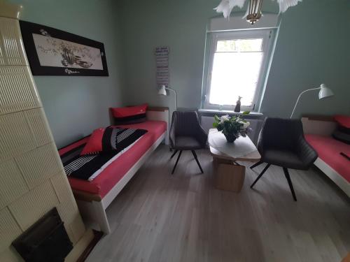 a room with two beds and a table and chairs at Ferienhaus Hüthchen in Eichhorst