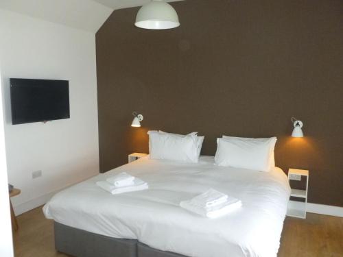 um quarto com uma cama branca com duas toalhas em Northstar 1 1 Bed Room with Ensuite em Wick