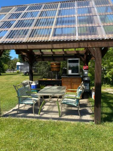 a picnic table and chairs under a gazebo at Dreamers Writing Farm, 3 Wooded Acres, Hepworth in Sauble Beach
